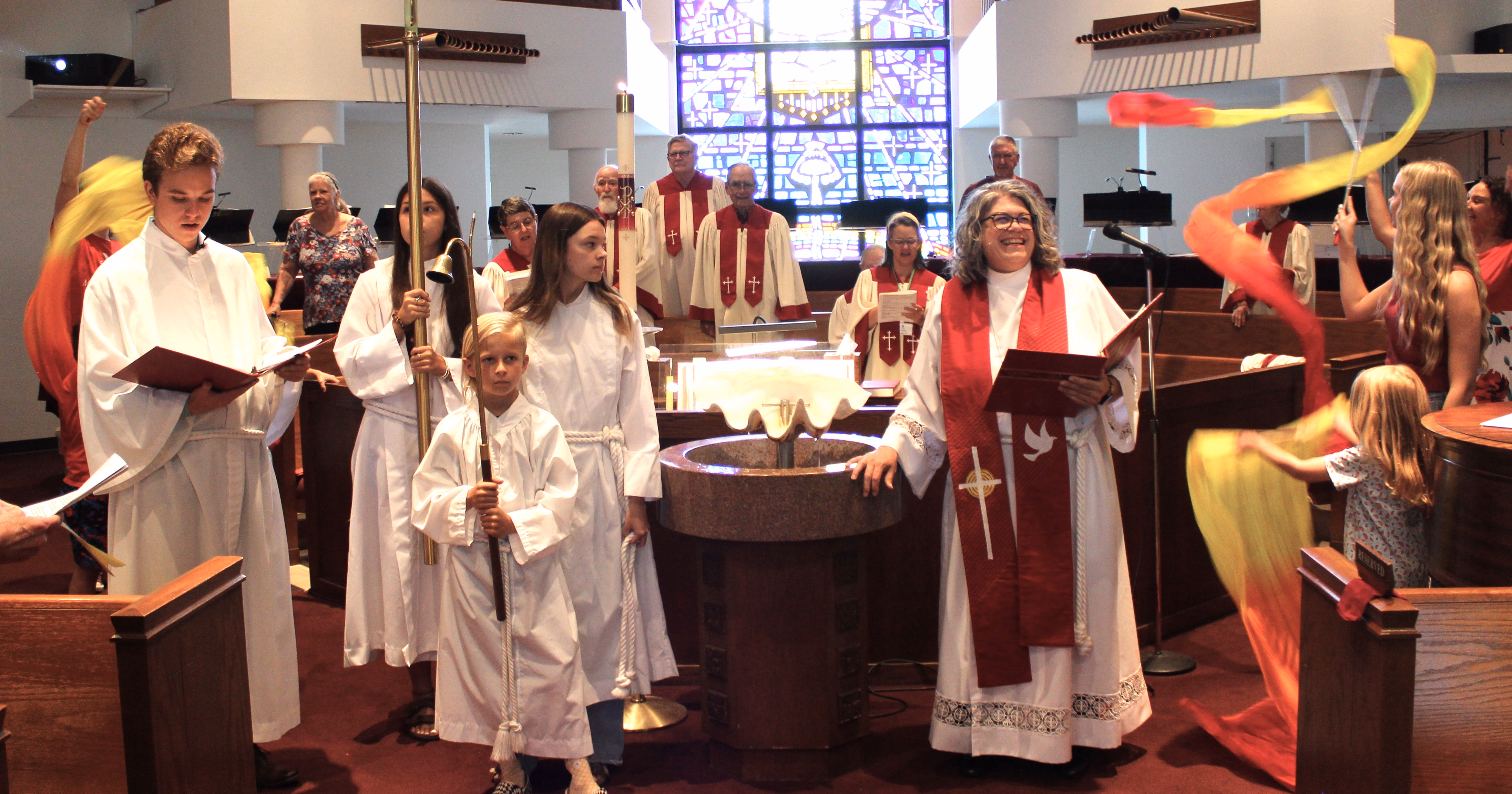 A baptism at the font during Sunday worship